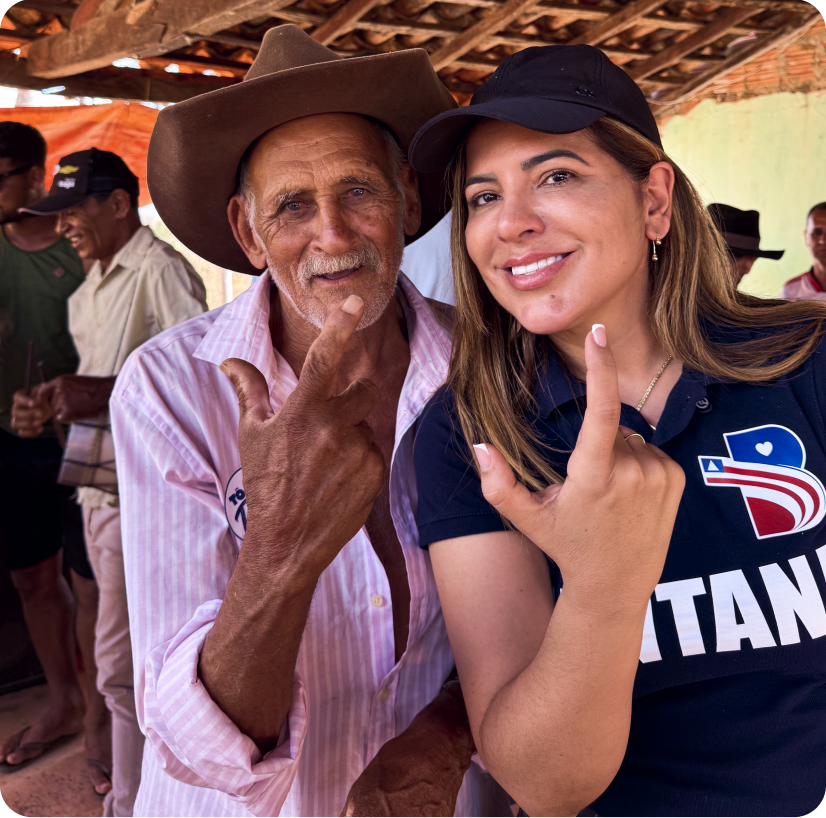Bete ao lado do senhor Reginaldo, os dois fazendo sinal com a mão, em reunião no distrito de Cuscuzeiro